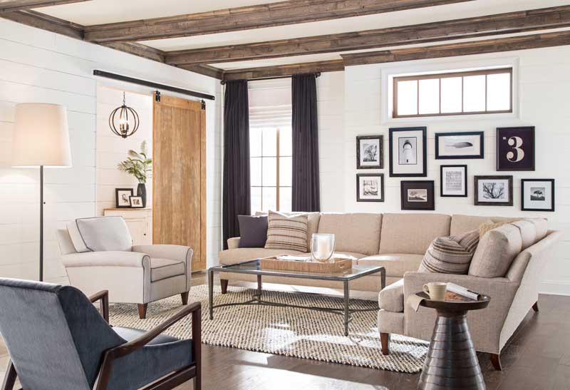 lifestyle photo with a tan sofa and a blue armchair with dark stained wooden arms